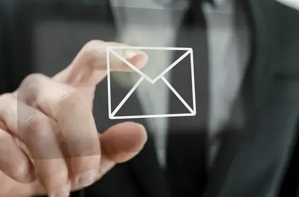 A hand touching an email envelope symbol